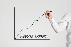 A person is drawing a website traffic bar graph in a blackboard