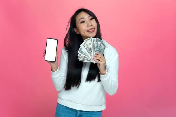 A person is holding a mobile phone and money showing that she can earn money using ads on apps