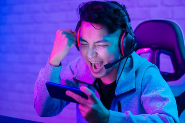 A person is celebrating a victory with a mobile device in his hands