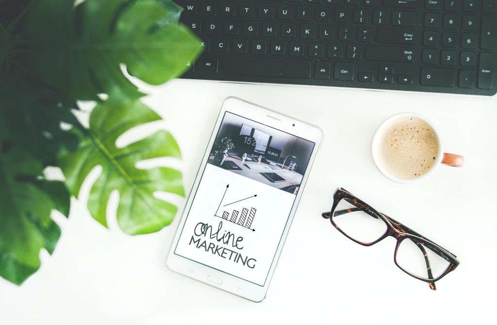 The image shows a table desk with a white paper where you can read Marketing Strategy