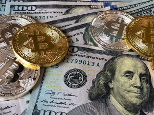 The image shows some dollars and crypto coins such Bitcoins