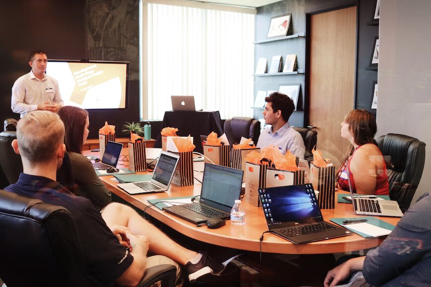 A group of persons with their laptops in an office