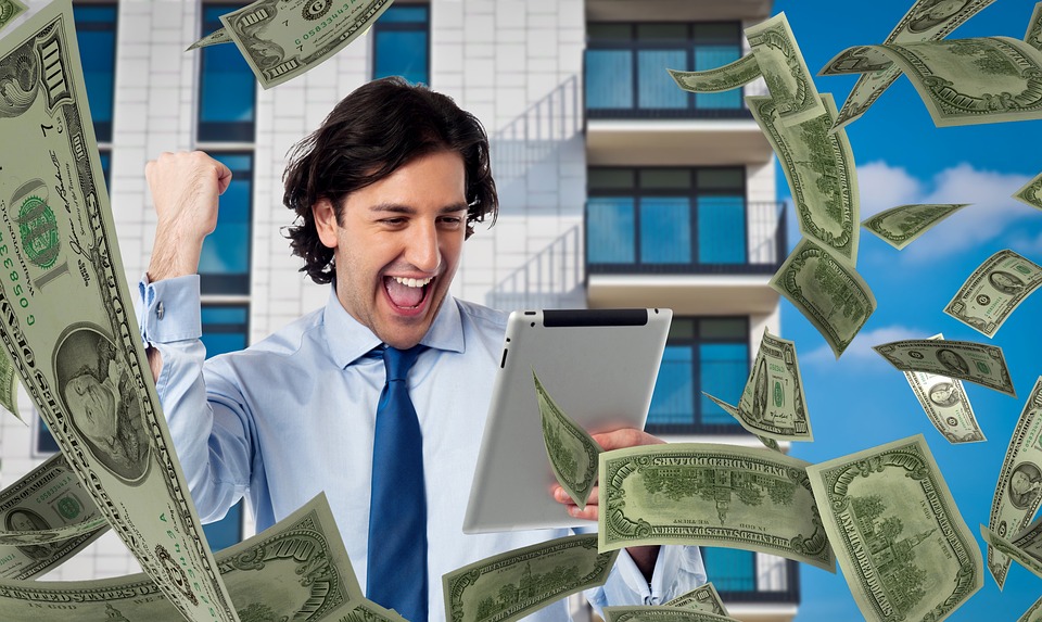 The image shows a person smiling with a tablet in his hand and money falling down
