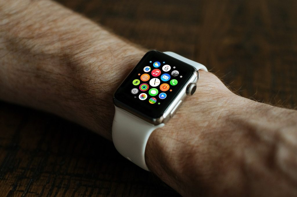 The image shows a smartwatch with many apps on the screen