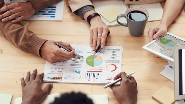 A group of persons are working as a team to analyze strategies for monetization