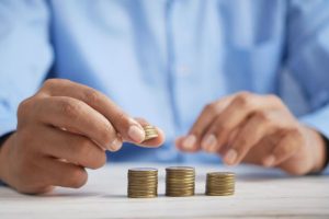 The image shows a person organizing coins on a table